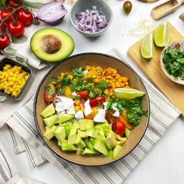 Overhead view of vegan elote bowl with rice and fresh veggie toppings