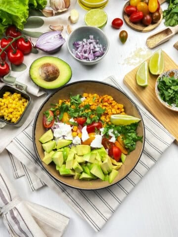 Overhead view of vegan elote bowl with rice and fresh veggie toppings