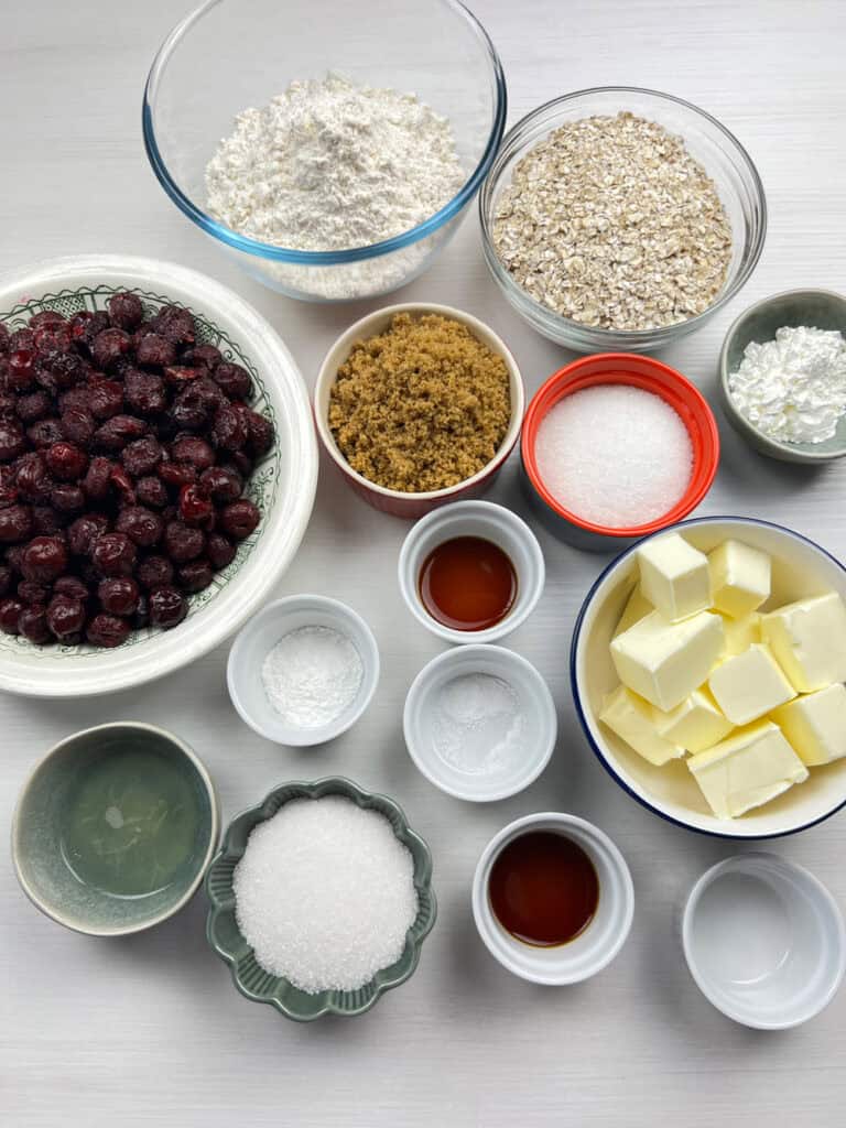 ingredients for cherry crumble including fresh cherries, oats, vegan butter and sugar