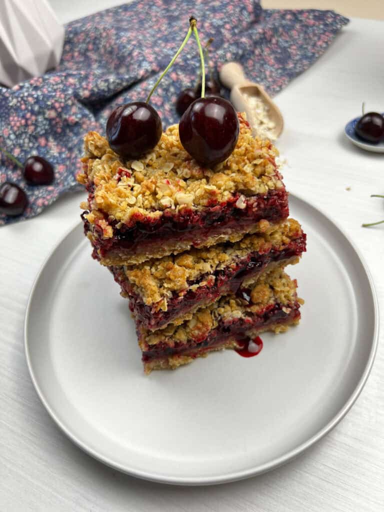 stack of vegan cherry crumb bars with a buttery oat topping, juicy filling and fresh cherries