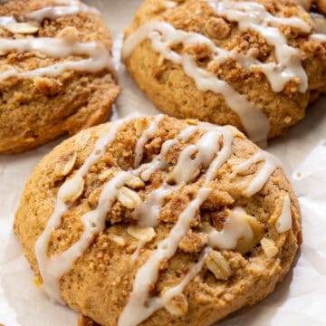 close up of vegan apple crisp cookies with juicy apples, cinnamon crumble, and vanilla glaze