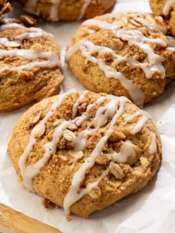 close up of vegan apple crisp cookies with juicy apples, cinnamon crumble, and vanilla glaze