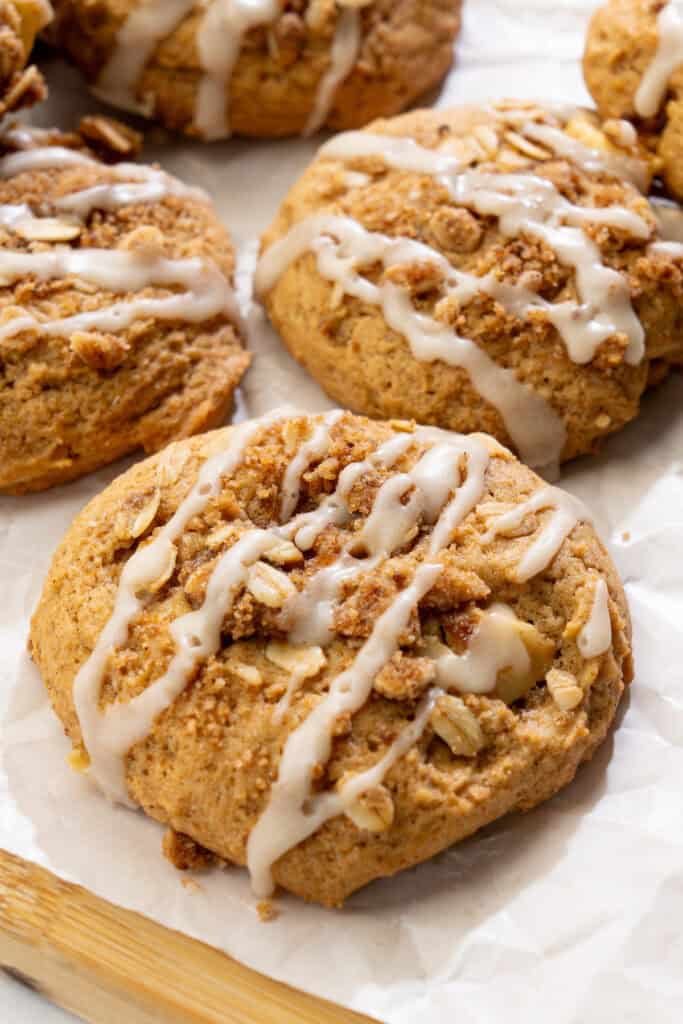 close up of vegan apple crisp cookies with juicy apples, cinnamon crumble, and vanilla glaze