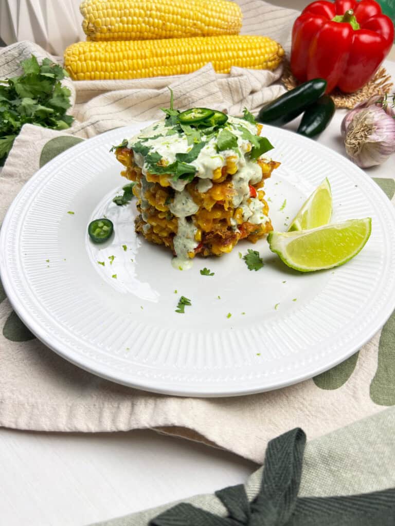 golden sweet corn pancakes topped with dairy-free jalapeno lime sauce and fresh cilantro