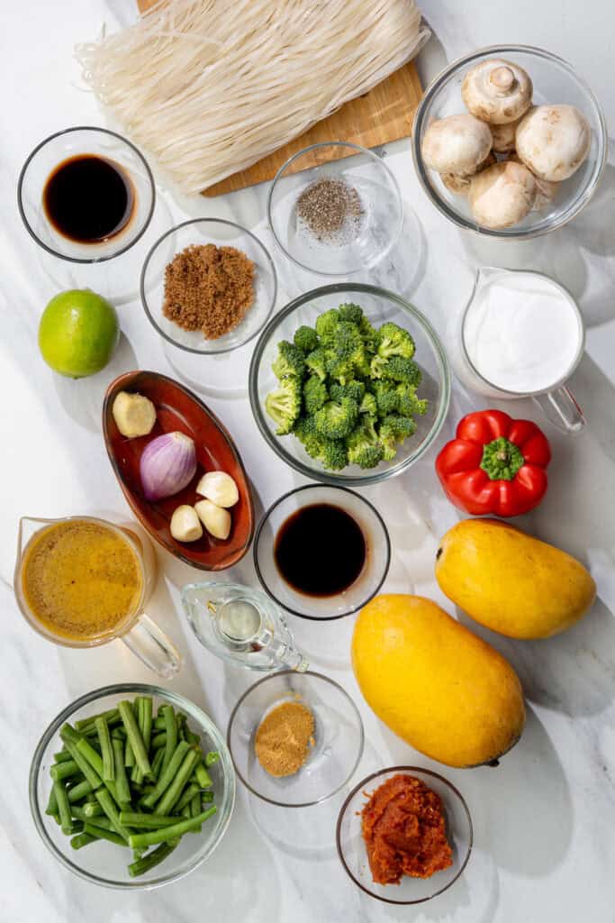 ingredients laid out for creamy mango curry soup with noodles, mushrooms and broccoli