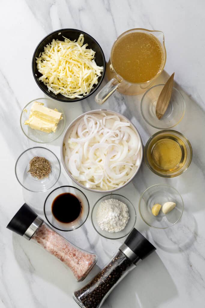 ingredients for vegan French onion soup including onions, vegetable broth, cheese shreds, wine and more
