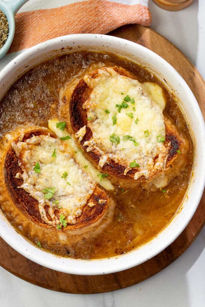 overhead shot of vegan French onion soup with caramelized onions and cheesy toasts