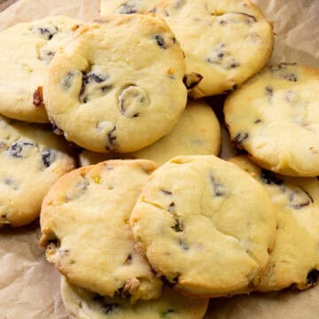 golden cranberry pistachio cookies arranged on parchment paper with soft centers and crispy edges