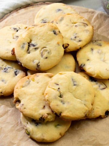 golden cranberry pistachio cookies arranged on parchment paper with soft centers and crispy edges