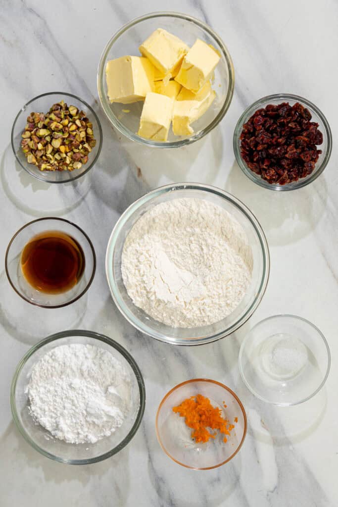 ingredients lined up for cranberry pistachio shortbread cookies including flour, sugar, and vegan butter