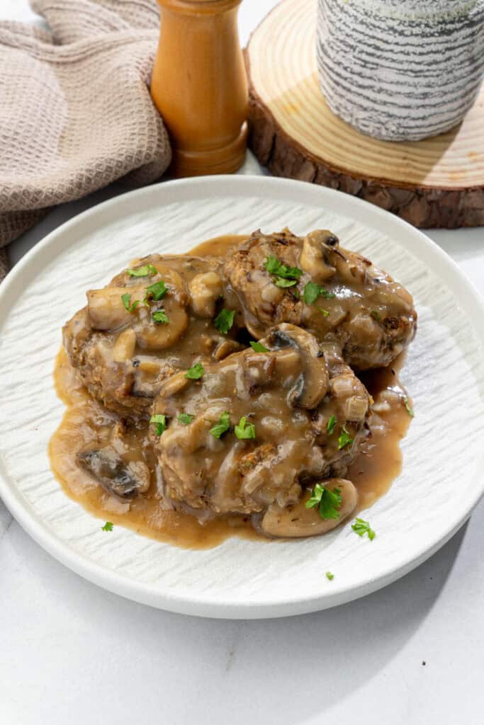 vegan minced meat steaks smothered in mushroom gravy served on a white plate