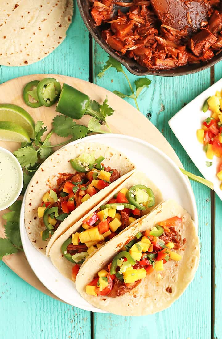 Three tacos on a white plate