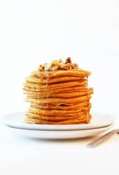 Stack of vegan Pumpkin Pancakes with pecans and maple syrup