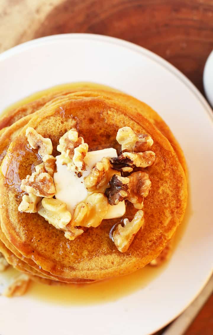 Close of up pumpkin pancakes with candied walnuts and maple syrup