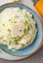 Close up of Cauliflower Mashed Potatoes with chives and butter.
