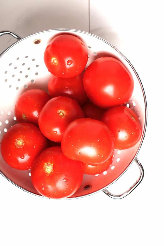 Fresh tomatoes in white colander