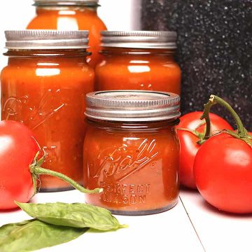 Canned tomato sauce next to canner