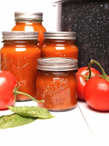 Canned tomato sauce next to canner