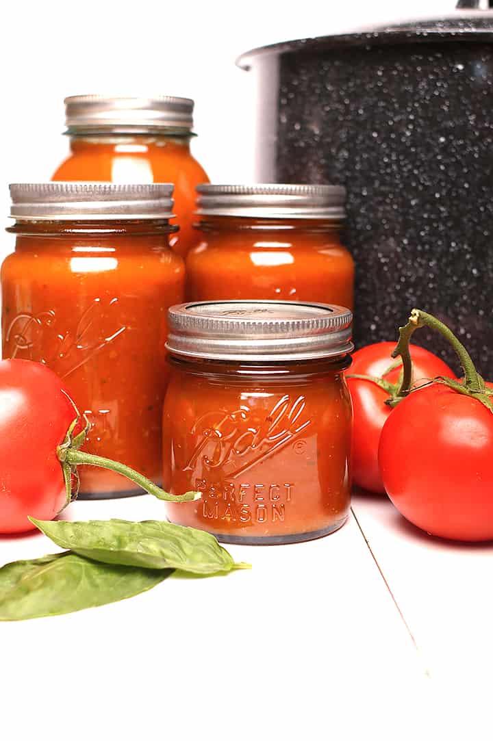 Canned tomato sauce next to canner