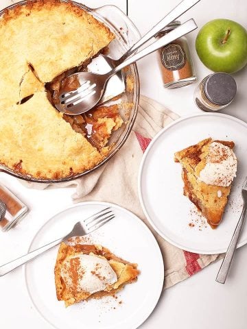 Two slices of apple pie on white plates