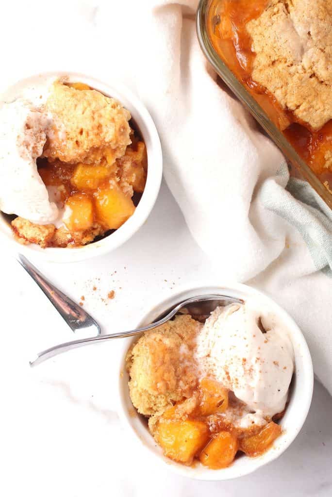 Two bowls of finished cobbler with vanilla ice cream